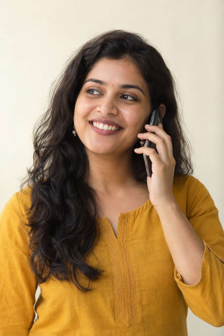 Illustrative portrait of a young adult Indian woman smiling while talking on the phone
